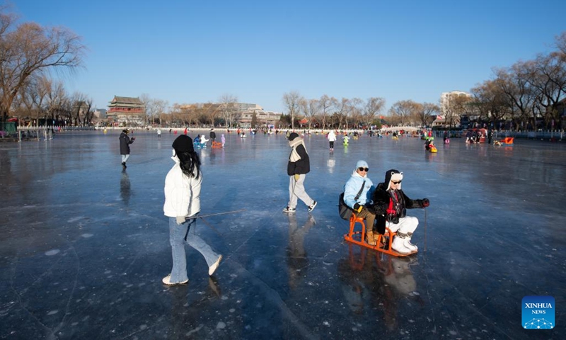 People play on the frozen Shichahai lake which has been turned to an ice rink in Beijing, capital of China, Dec. 27, 2022. The ice rink opened to the public on Tuesday.(Photo: Xinhua)