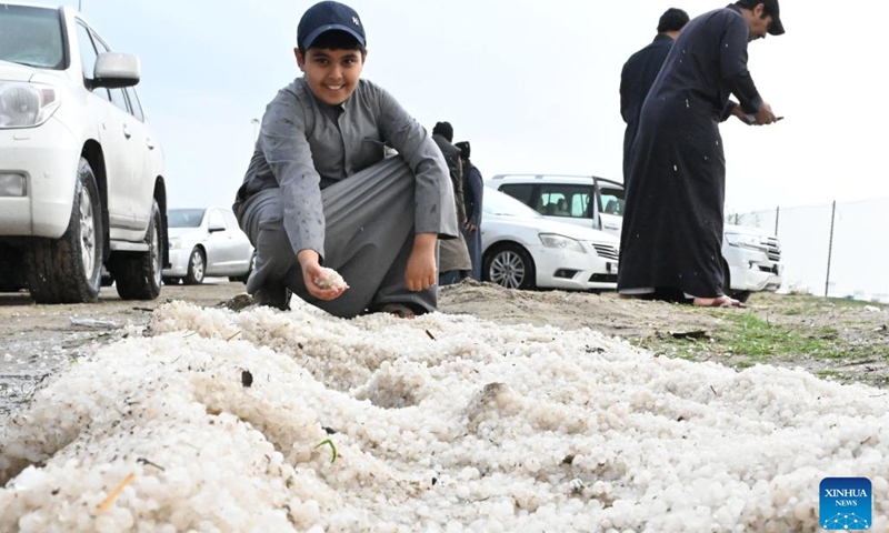 A boy shows hailstones in Ahmadi Governorate, Kuwait, on Dec. 27, 2022. Hail lashed a number of areas in Kuwait on Tuesday.(Photo: Xinhua)