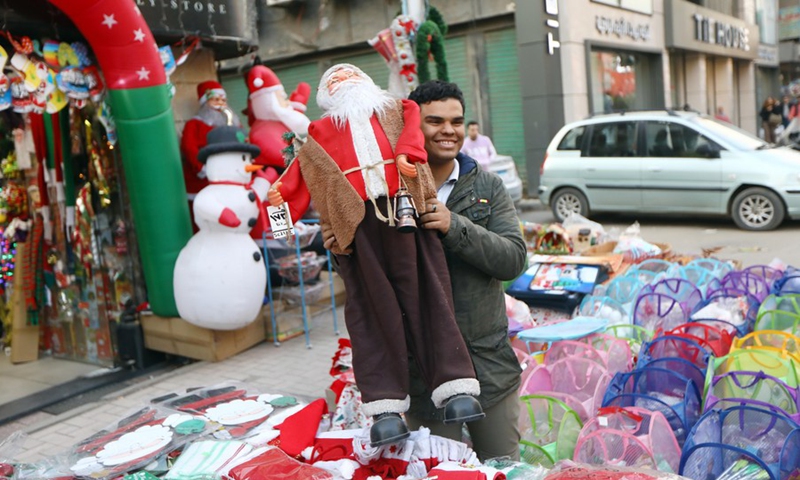 A man holds a Santa Claus doll in front of a store in Cairo, Egypt, Dec. 27, 2022.(Photo: Xinhua)