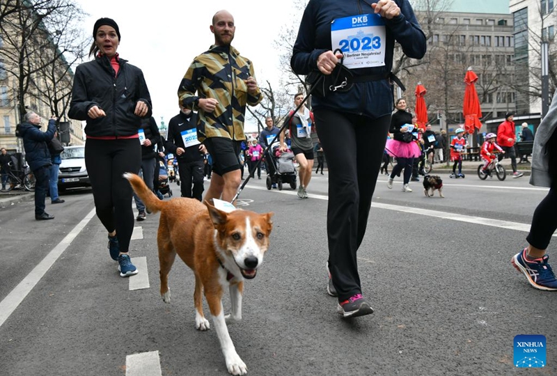 A dog and its owner take part in the New Year's Run in Berlin, Germany, Jan. 1, 2023. The event kicked off here on Sunday. (Xinhua/Ren Pengfei)