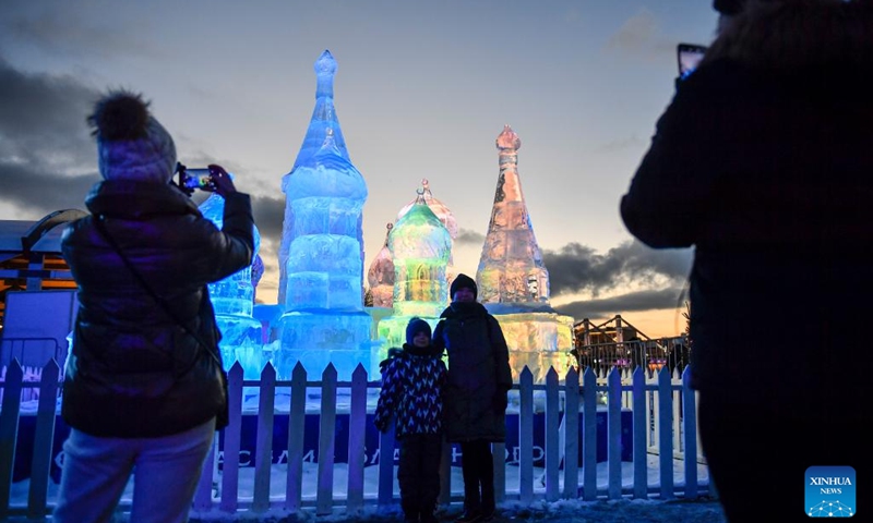 People pose for photos in front of an ice sculpture at a park in Moscow, Russia, on Jan. 5, 2023.(Photo: Xinhua)