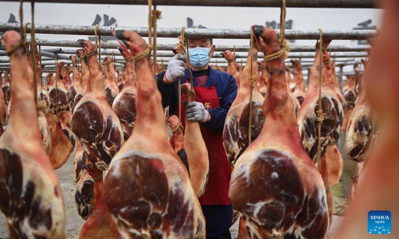 A worker checks the quality of ham dried at a ham-making factory in Jindong District of Jinhua City, east China's Zhejiang Province, Jan. 4, 2023. As the Spring Festival approaches, local enterprises vigorously produce Jinhua ham to meet the demand of festival market.(Photo: Xinhua)