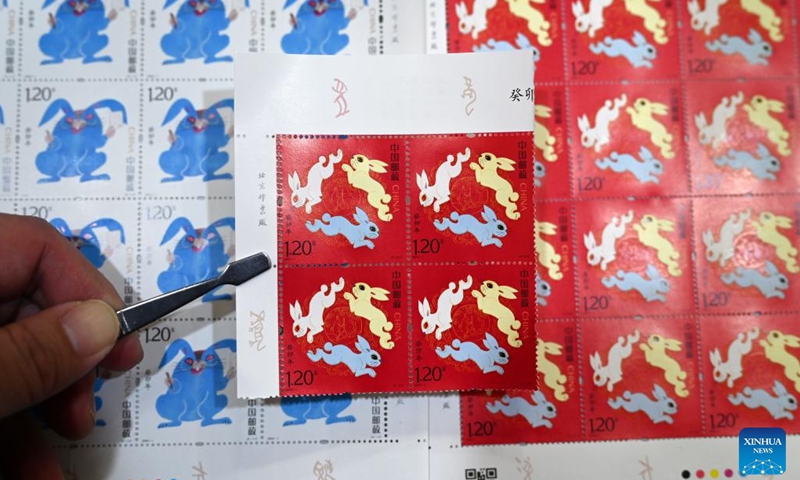 A stamp collector displays the newly-purchased special stamps marking the Year of the Rabbit in Dongxing District of Neijiang, southwest China's Sichuan Province, Jan. 5, 2023. China Post on Thursday released a set of two special stamps to celebrate the upcoming Chinese zodiac Year of the Rabbit.(Photo: Xinhua)