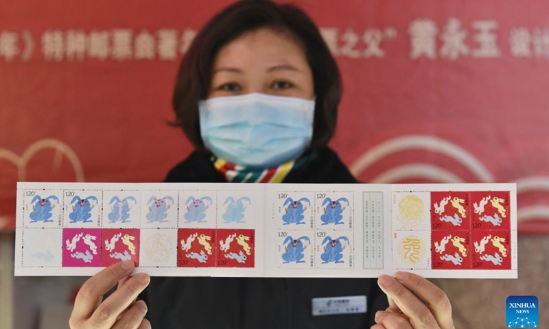 A staff member of China Post displays the special stamps marking the Year of the Rabbit in Fuyang, east China's Anhui Province, Jan. 5, 2023. China Post on Thursday released a set of two special stamps to celebrate the upcoming Chinese zodiac Year of the Rabbit.(Photo: Xinhua)