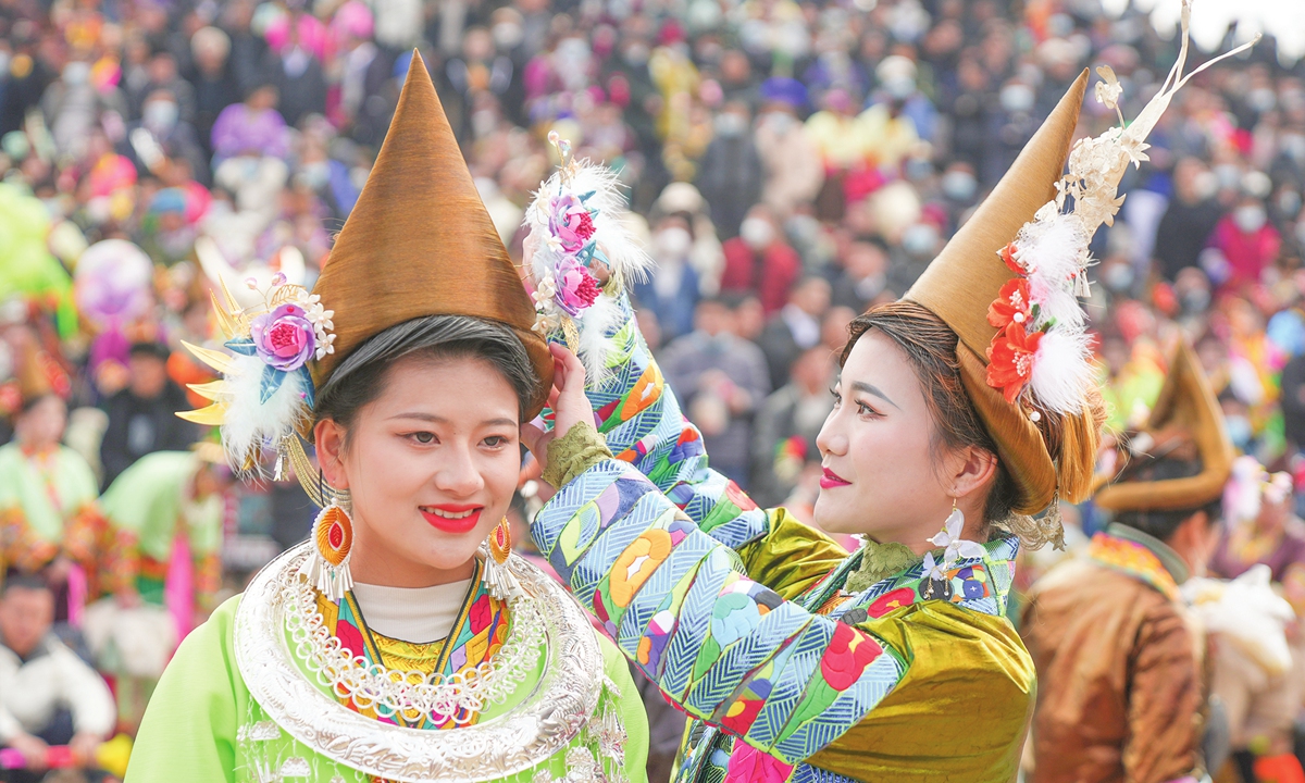 A woman tidies up her friend's clothes as a Miao village holds its traditional Lusheng Festival in Liuzhou, South China's Guangxi Zhuang Autonomous Region on January 3, 2023. Photo: VCG