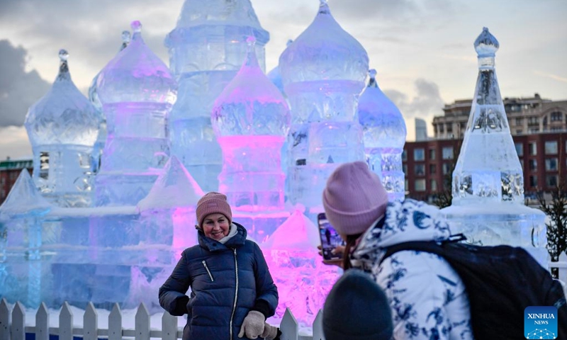 A woman poses for photos in front of an ice sculpture at a park in Moscow, Russia, on Jan. 5, 2023.(Photo: Xinhua)