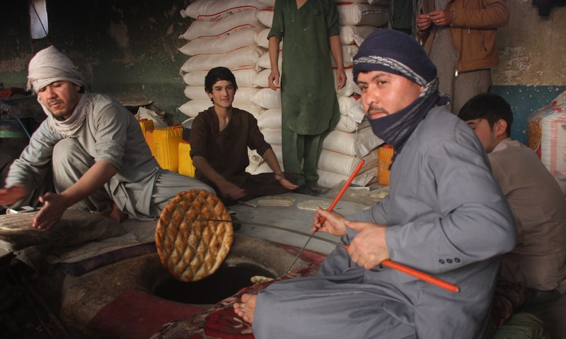 Afghan men prepare naan for sale at a bakery in Balkh province, Afghanistan on Jan. 24, 2023. Photo: Xinhua