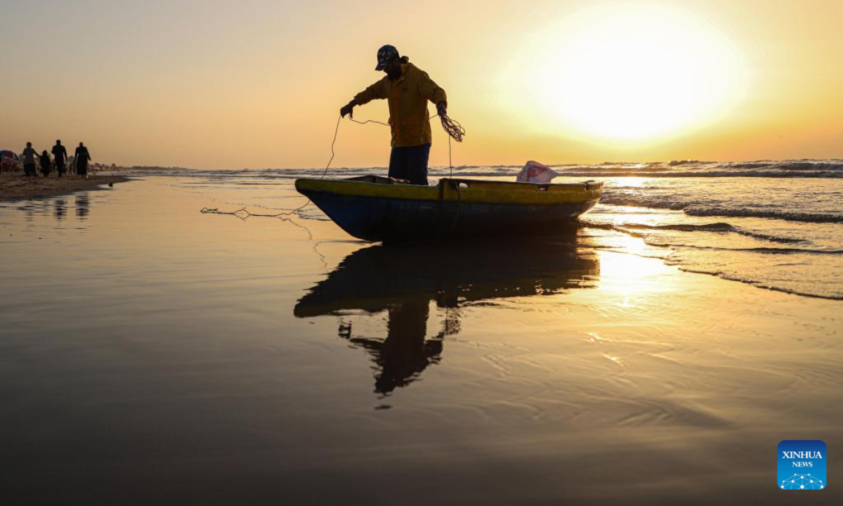 A fisherman prepares to go fishing on a beach of the Mediterranean Sea at sunset in Gaza City, on Feb 10, 2023.Photo:Xinhua