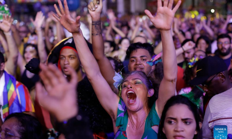 Revelers listen to traditional frevo music from Pernambuco, during the inauguration of carnival at Marco Zero in Recife, Pernambuco, Brazil, Feb. 17, 2023. A carnival with local cultural features kicked off in Recife on Friday. About 25,000 people attended its opening ceremony and parades. Photo: Xinhua