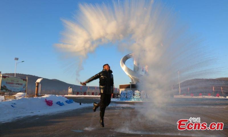 A tourist splashes hot water into the cold air in Huzhong District, one of the coldest places in China, northeast China's Heilongjiang Province, Jan. 5, 2023. The water immediately turns into ice crystals.(Photo: China News Service/Zhang Zhao)