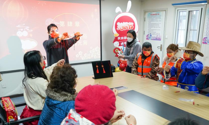 Construction workers of the China Construction Third Engineering Bureau Co., Ltd. and local residents learn to make Chinese knots in Nanjing, east China's Jiangsu Province, Feb. 4, 2023. The Lantern Festival, the 15th day of the first month of the Chinese lunar calendar, falls on Feb. 5 this year. Various folk cultural activities were held across the country to welcome the upcoming festival. Photo: Xinhua