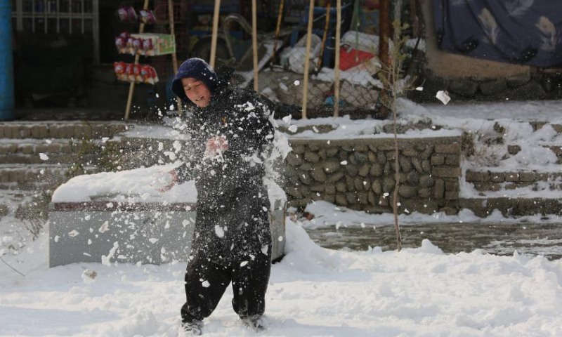 A child plays with snow in Kabul, Afghanistan, Jan. 23, 2023. Afghan capital was blanketed in snow on Monday. (Photo by Saifurahman Safi/Xinhua)