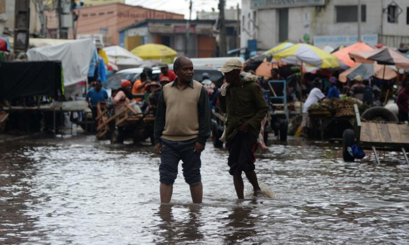 People are seen on a flooded area in Antananarivo, Madagascar, on Jan. 25, 2023. The death toll has risen to 16 with 19 people still missing after the strong tropical storm Cheneso hit Madagascar, according to the latest report released Thursday by the National Office for Risk and Disaster Management (BNGRC). Photo: Xinhua