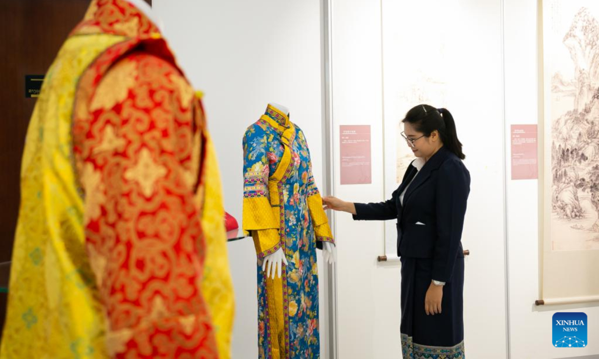 A visitor watches traditional clothes at the Ancient Chinese Landscape Painting Exhibition themed 