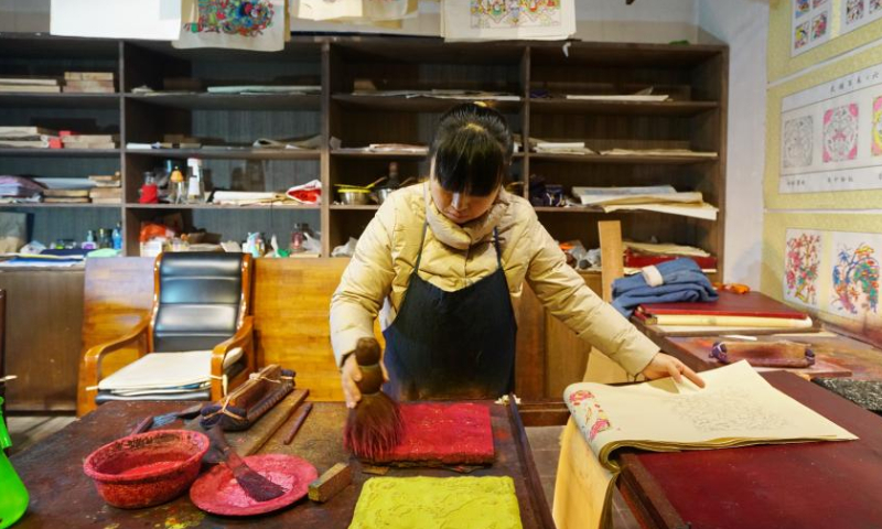 An artist makes woodblock paintings at the Wuqiang woodblock new year painting museum in Wuqiang County, north China's Hebei Province, Feb. 3, 2023. Wuqiang County has made efforts to pass on and promote the culture of Wuqiang woodblock new year painting, a national intangible cultural heritage listed in 2006. A series of cultural and creative products made with modern technology has been introduced to attract youngsters. Photo: Xinhua