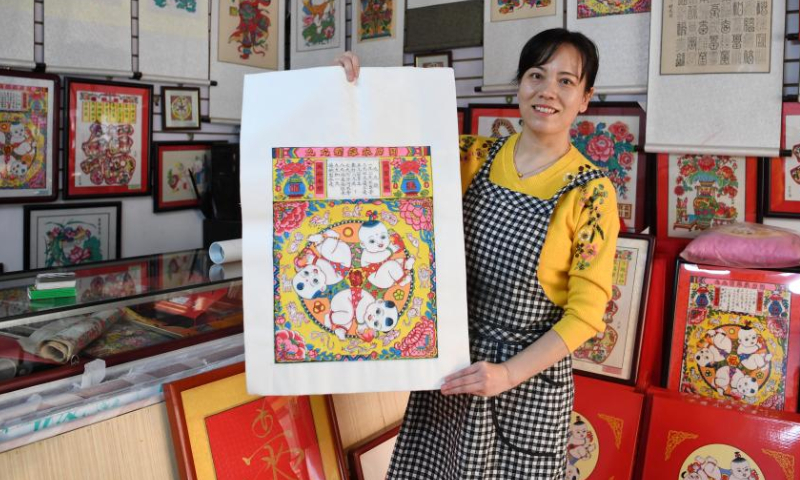 A staff member displays a woodblock new year painting at a workshop in Wuqiang County, north China's Hebei Province, Feb. 3, 2023. Wuqiang County has made efforts to pass on and promote the culture of Wuqiang woodblock new year painting, a national intangible cultural heritage listed in 2006. A series of cultural and creative products made with modern technology has been introduced to attract youngsters. Photo: Xinhua