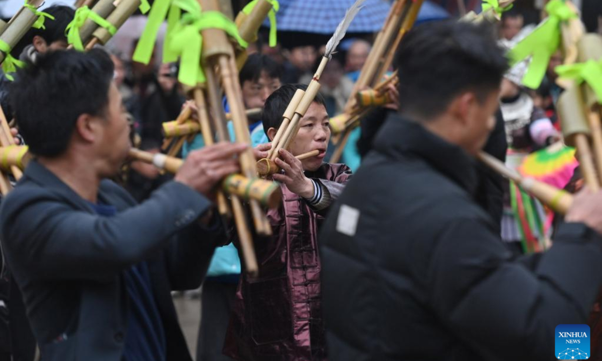 People of Miao ethnic group blow Lusheng, a traditional reed-pipe wind instrument, during the 