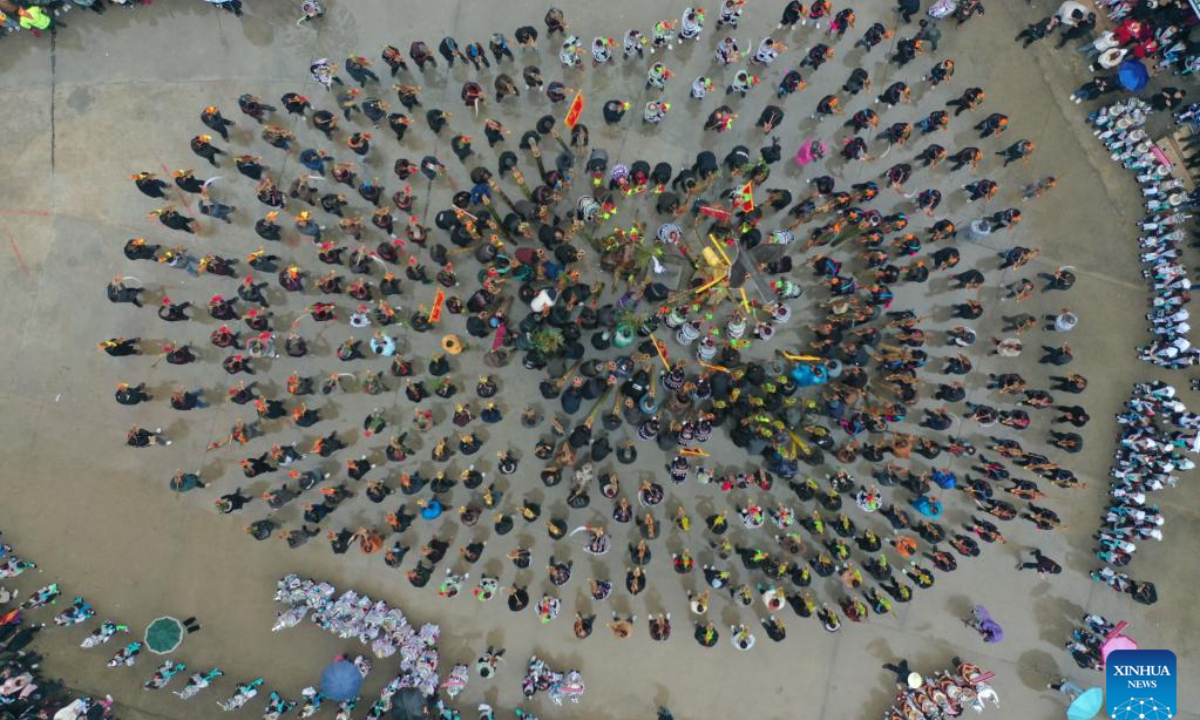 People of various ethnic groups blow Lusheng, a traditional reed-pipe wind instrument, during the 