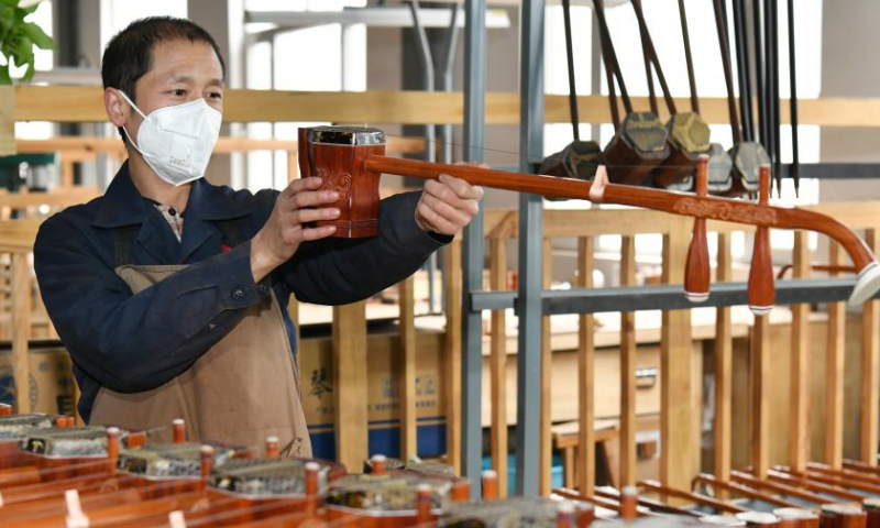 A worker checks the quality of traditional Chinese musical instrument Erhu at a workshop in Suning County, north China's Hebei Province, Feb. 18, 2023. Photo: Xinhua