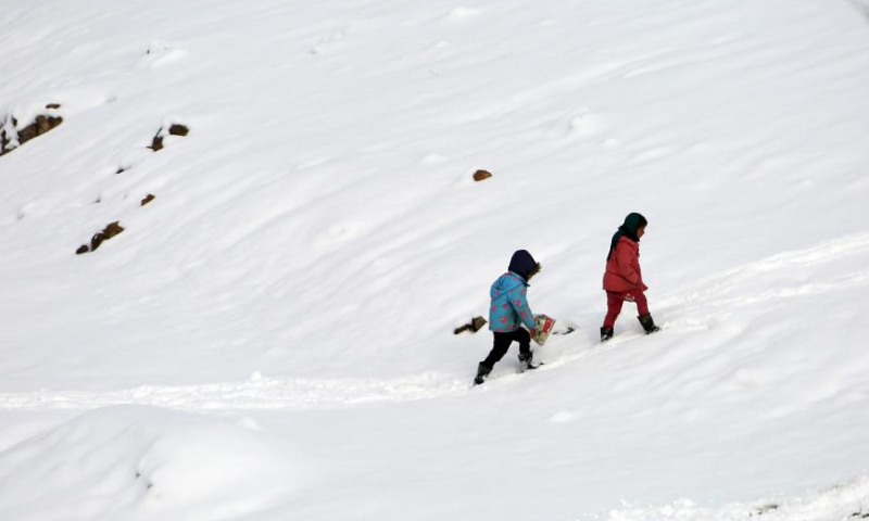 Children walk in snow in Kabul, Afghanistan, Jan. 23, 2023. Afghan capital was blanketed in snow on Monday. (Photo by Saifurahman Safi/Xinhua)