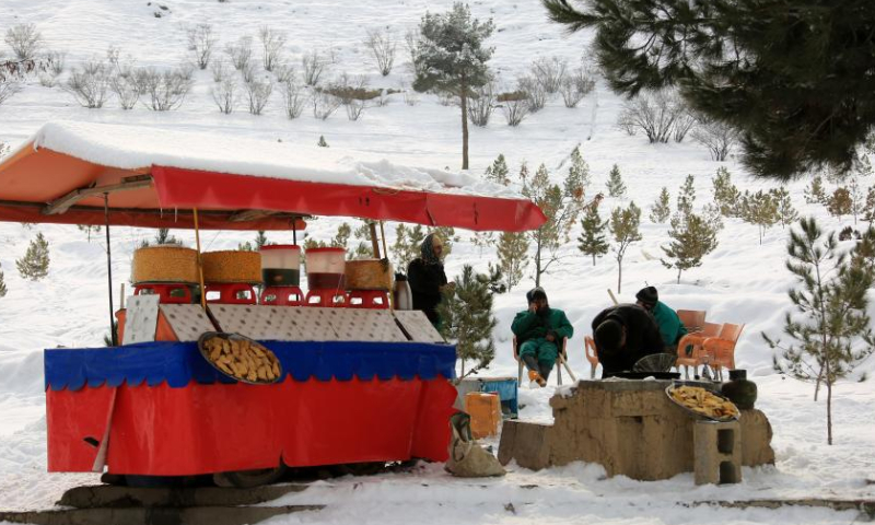 A vendor waits for customers in snow in Kabul, Afghanistan, Jan. 23, 2023. Afghan capital was blanketed in snow on Monday. (Photo by Saifurahman Safi/Xinhua)