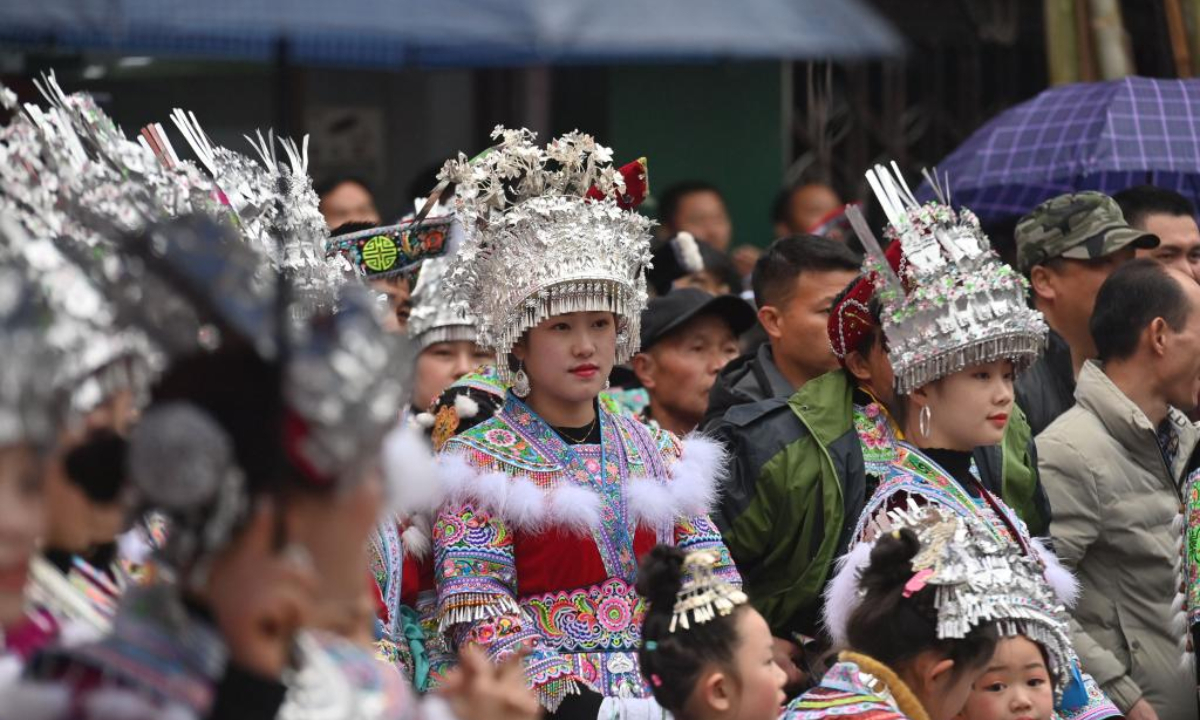 Girls of Miao ethnic group watch folk performances during the 