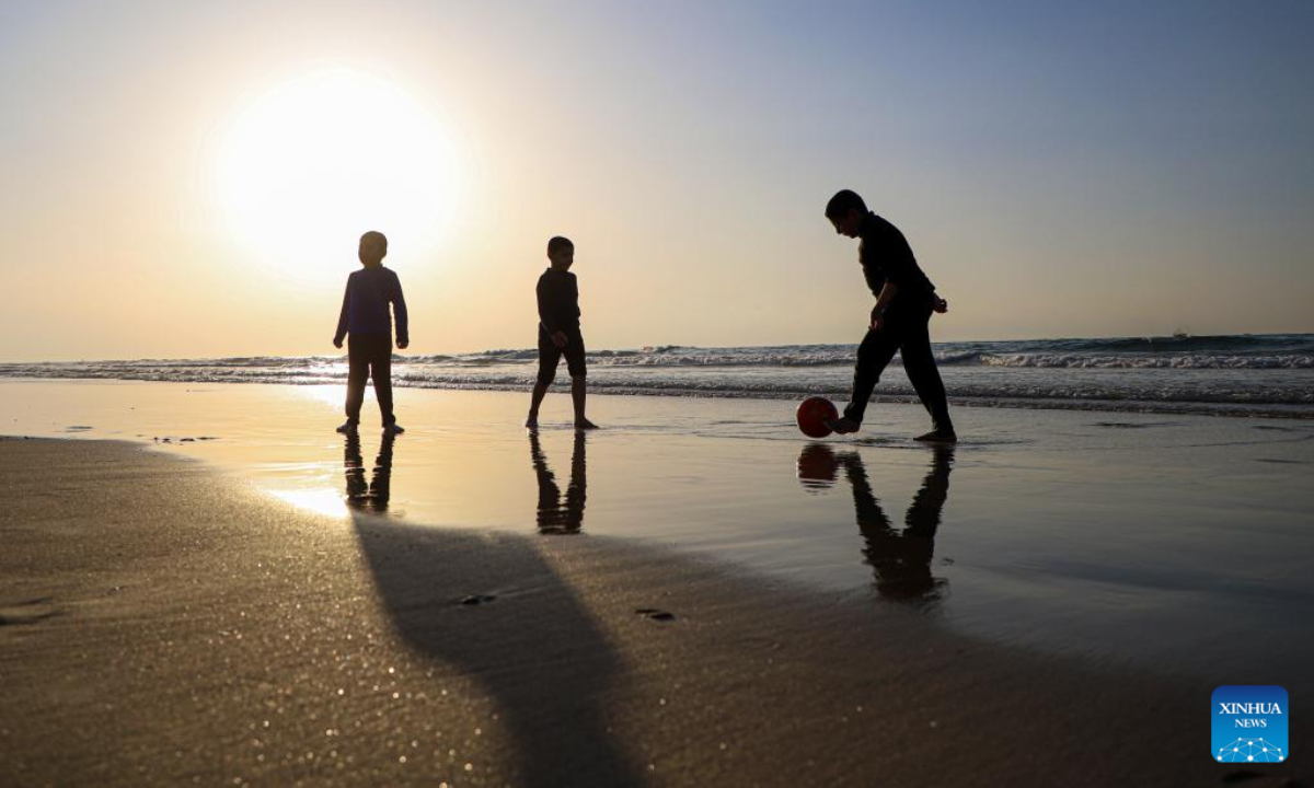 Children play a ball on a beach of the Mediterranean Sea at sunset in Gaza City, on Feb 10, 2023. Photo:Xinhua