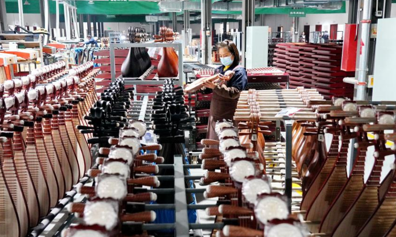 A worker puts traditional Chinese musical instruments in place at a workshop in Suning County, north China's Hebei Province, Feb. 18, 2023. Photo: Xinhua