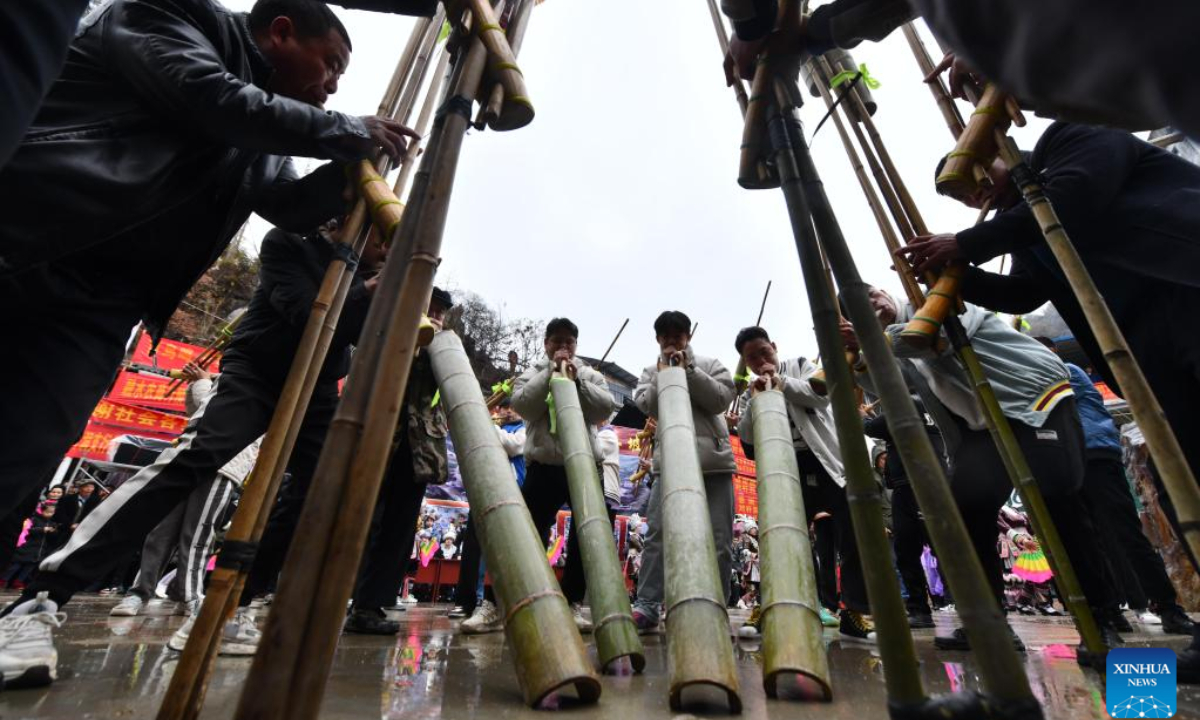 People of Miao ethnic group blow Lusheng, a traditional reed-pipe wind instrument, during the 