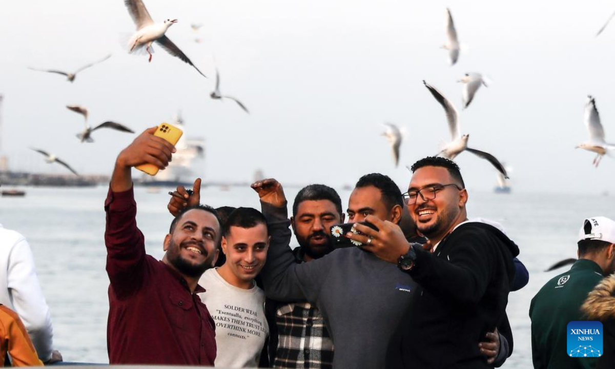 People take a selfie with gulls flying over the Suez Canal in Port Said, Egypt, on Jan 5, 2023. Photo:Xinhua