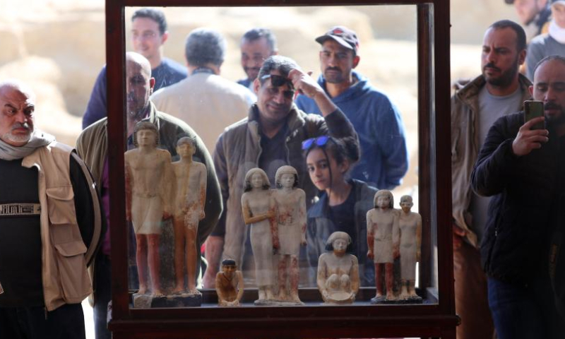 People look at cultural relics unearthed from newly-discovered ancient tombs in Saqqara necropolis, south of Cairo, Egypt, on Jan. 26, 2023. Egypt's renowned archeologist Zahi Hawass on Thursday announced the discovery of 