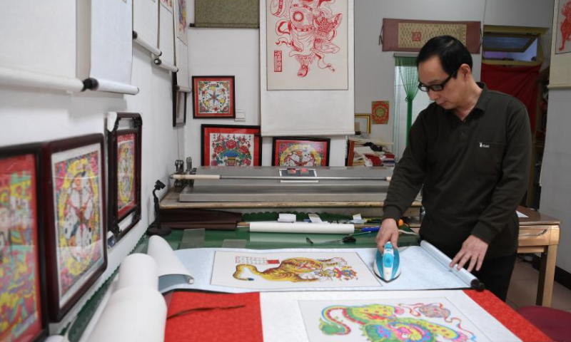 An artist makes woodblock paintings at the Wuqiang woodblock new year painting museum in Wuqiang County, north China's Hebei Province, Feb. 3, 2023. Wuqiang County has made efforts to pass on and promote the culture of Wuqiang woodblock new year painting, a national intangible cultural heritage listed in 2006. A series of cultural and creative products made with modern technology has been introduced to attract youngsters. Photo: Xinhua