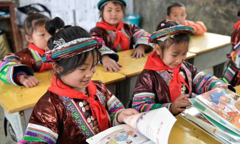 Students receive new books at the Zhongzhai education spot in Xishan Town of Congjiang County, Qiandongnan Miao and Dong Autonomous Prefecture, southwest China's Guizhou Province, Feb. 16, 2023. Zhongzhai education spot, located in the remote mountainous area of Guizhou Province, has only one teacher and 16 students of Yao ethnic group. In recent years, the conditions of this mini primary school have been greatly improved with the help of local government and community. Photo: Xinhua