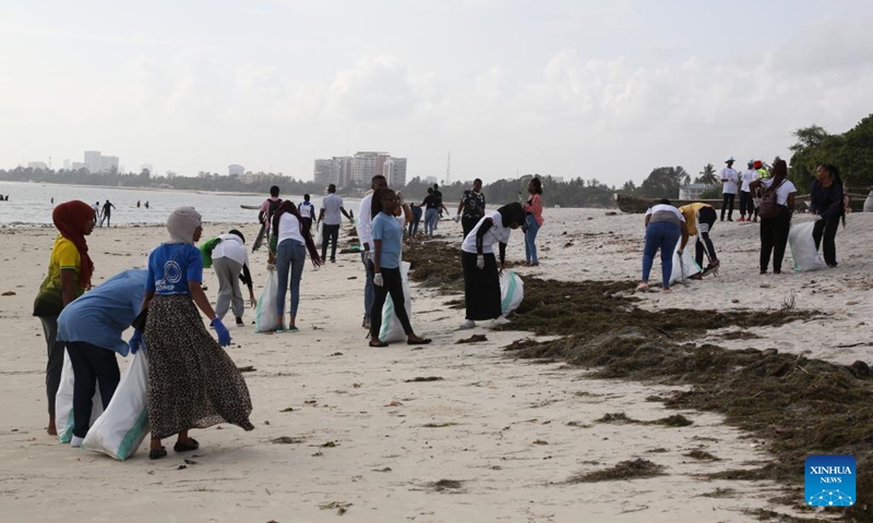 Young people clean up trash at a beach in Tanzania's port city of Dar es Salaam, Jan. 7, 2023. (Photo by Herman Emmanuel/Xinhua)