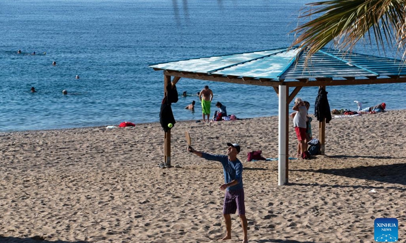 People spend time at a beach in Faliro, a southern suburb of Athens, Greece, on Jan. 6, 2023. Greece has been experiencing unseasonably warm temperatures this winter, prompting people to head for the beach instead of the ski resorts. However, the mild weather leaves scientists concerned.(Photo: Xinhua)