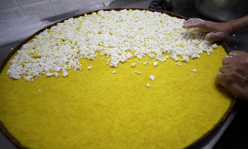 A Palestinian cook prepares Nabulsia, a cheese pastry soaked in sweet sugar-based syrup, at a market in the West Bank city of Nablus, on Jan. 11, 2023.(Photo: Xinhua)