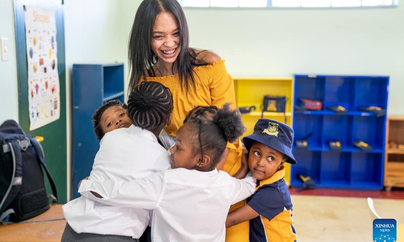 Students hug their teacher on the first day of a new semester at a school in Johannesburg, South Africa, Jan. 11, 2023. Schools in Johannesburg started a new semester this week.(Photo: Xinhua)