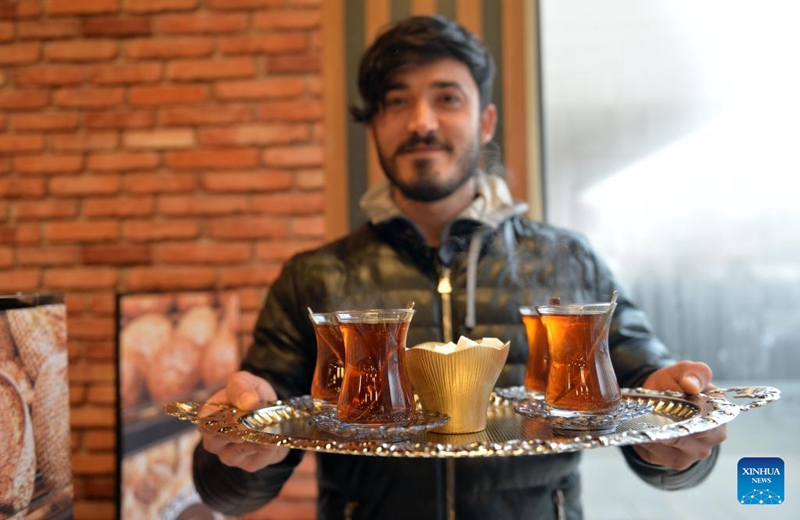 A waiter serves tea to customers at a cafe in Ankara, Türkiye, Jan. 6, 2023. (Photo by Mustafa Kaya/Xinhua)