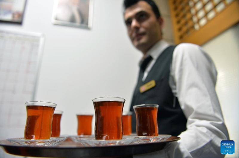 A waiter serves tea to customers at a cafe in Ankara, Türkiye, Jan. 6, 2023. (Photo by Mustafa Kaya/Xinhua)