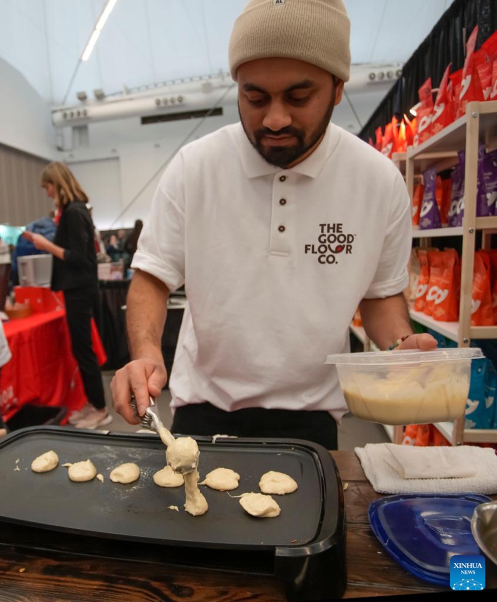 A vendor prepares food samples at a booth during the Gluten Free Expo in Vancouver, British Columbia, Canada, on Jan. 15, 2023. (Photo by Liang Sen/Xinhua)