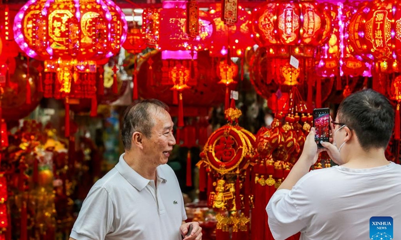 A customer takes pictures of decorations for the upcoming lunar New Year at the Chinatown in Manila, the Philippines, Jan. 18, 2023(Photo: Xinhua)