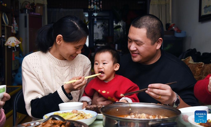 People enjoy a feast on the eve of the Spring Festival at their home in Beijing, capital of China, Jan. 21, 2023. On the eve of the Spring Festival in China, while some people reunite with their families and friends, there are others who still stick to their posts away from home. Nevertheless, nothing can stop a warm gathering and delicious festive dinner while they await the arrival of the Spring Festival. (Xinhua/Ren Chao)