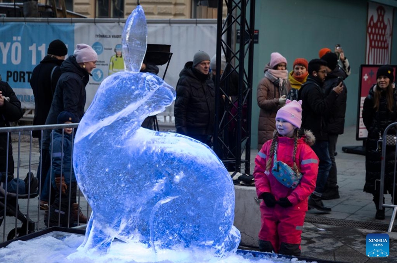 A girl looks at a rabbit-themed ice sculpture made in celebration of the Chinese New Year in Helsinki, Finland, Jan. 21, 2023. (Photo by Matti Matikainen/Xinhua)