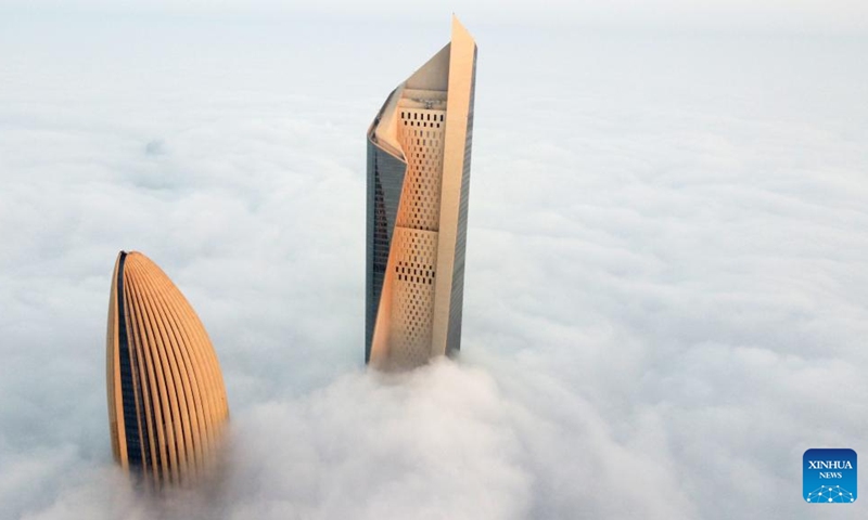 This aerial photo taken on Jan. 21, 2023 shows skyscrapers shrouded by cloud and fog in Kuwait City, Kuwait. (Photo by Asad/Xinhua)