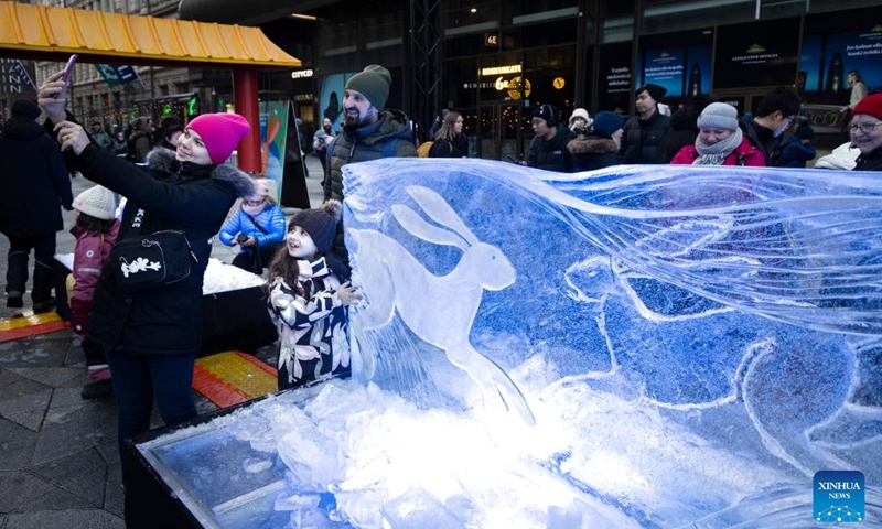 People take a selfie with a rabbit-themed ice sculpture made in celebration of the Chinese New Year in Helsinki, Finland, Jan. 21, 2023. (Photo by Matti Matikainen/Xinhua)