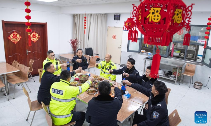 Police officers and auxiliary police officers enjoy a feast on the eve of the Spring Festival at the canteen of Dongshan Police Station in Yichang, central China's Hubei Province, Jan. 21, 2023. (Xinhua/Xiao Yijiu)