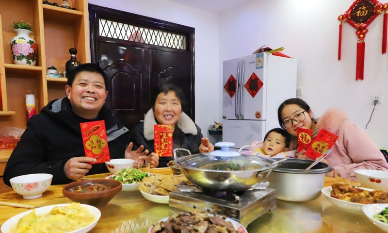 People pose for a photo during a family feast in Feixi County, Hefei, east China's Anhui Province, Jan. 21, 2023. On the eve of the Spring Festival in China, while some people reunite with their families and friends, there are others who still stick to their posts away from home. Nevertheless, nothing can stop a warm gathering and delicious festive dinner while they await the arrival of the Spring Festival. (Photo by Chen Jiale/Xinhua)