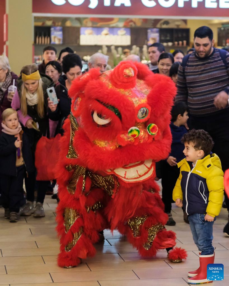 People watch lion dance in Sliema, Malta, Jan. 28, 2023. An event to celebrate the Chinese New Year or Spring Festival was held in a shopping mall in Sliema on Saturday. (Photo by Jonathan Borg/Xinhua)