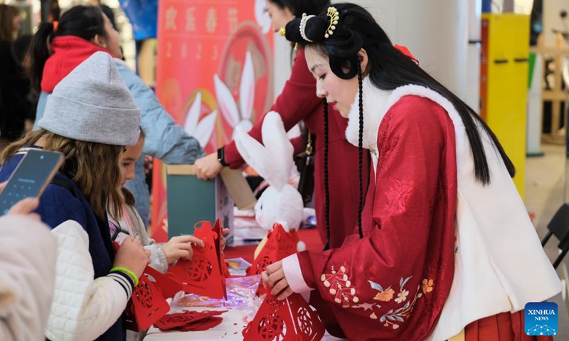 Children learn to fold lanterns with the Chinese character fu, which means good fortune, in Sliema, Malta, Jan. 28, 2023. An event to celebrate the Chinese New Year or Spring Festival was held in a shopping mall in Sliema on Saturday. (Photo by Jonathan Borg/Xinhua)