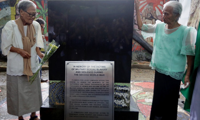 Former Philippine comfort women Estelita Dy (L), 90 years old, and Narcisa Claveria, 91 years old, present flowers to the new historical marker titled In Memory of the Victims of Military Sexual Slavery and Violence During the Second World War in Paranaque City in Metro Manila, the Philippines on Aug. 25, 2019.(Photo: Xinhua)